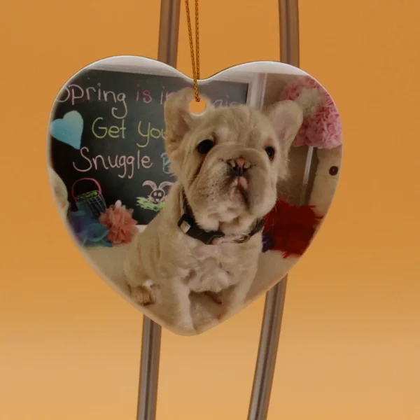 A dog is sitting on the ground in front of a heart shaped picture frame.