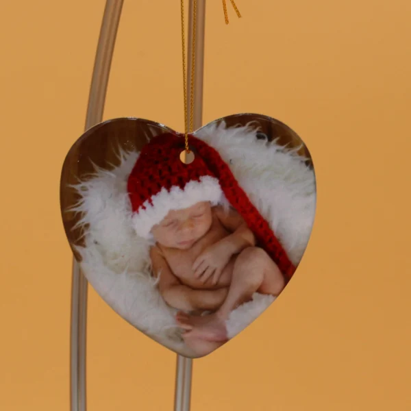 A heart shaped ornament with a baby in it.