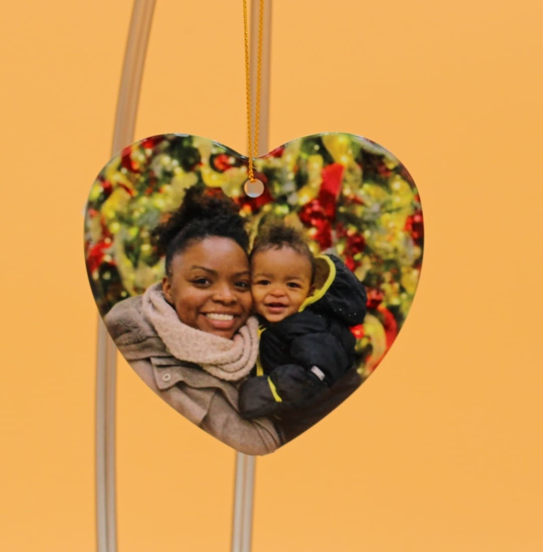 A heart shaped picture frame with a woman and child.