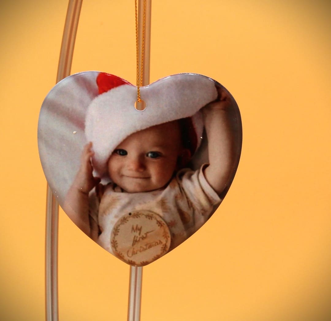 A heart shaped ornament with a picture of a child.