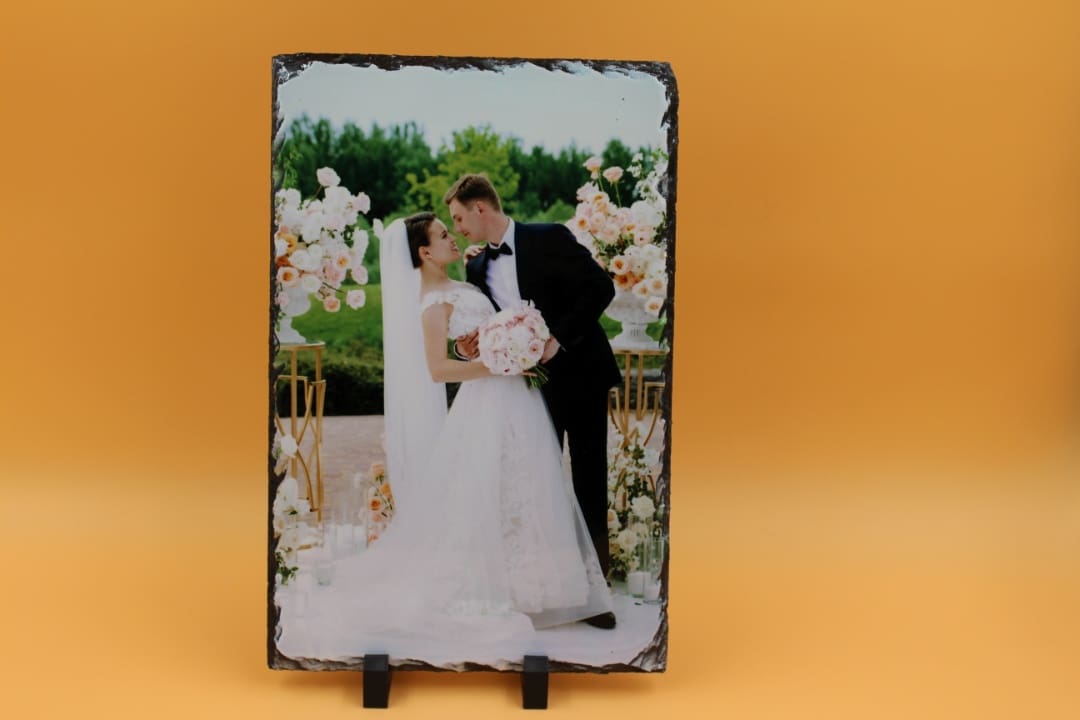 A couple is standing in front of flowers.